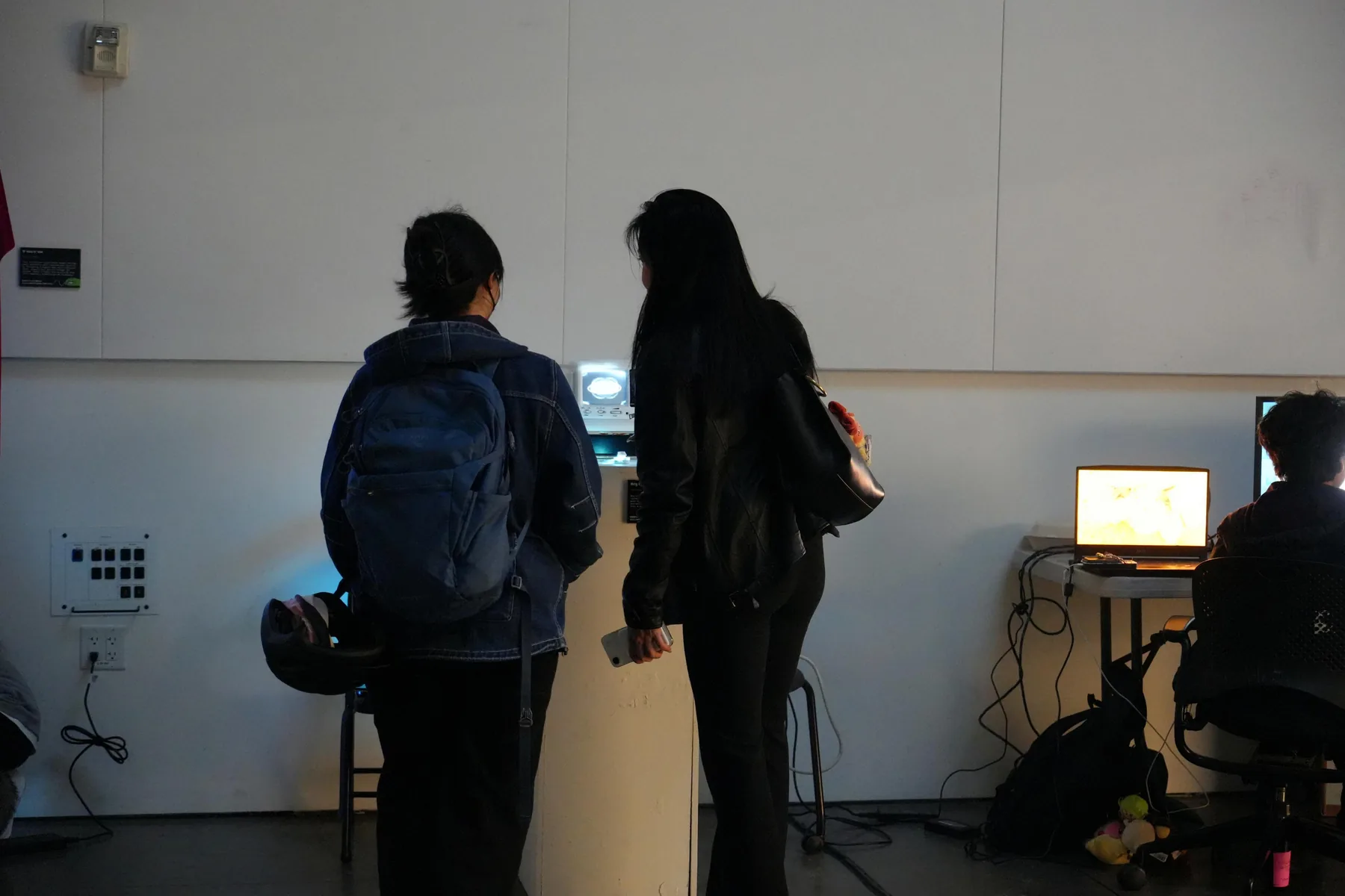 Two visitors approaching Hey, Cili in the gallery